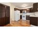 Bright kitchen with hardwood floors, white appliances, and dark wood cabinets at 350 S Clinton St # 2A, Denver, CO 80247