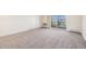 The living room features neutral carpet, window coverings, and a sliding glass door to the patio at 350 S Clinton St # 2A, Denver, CO 80247