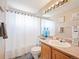 Cozy bathroom featuring a vanity with a white sink, a toilet, and a shower with a white curtain at 11302 W Prentice Dr, Littleton, CO 80127