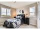 Bedroom with a large window, railroad decorations, and a comfortable, patterned comforter on the bed at 1839 Morgan Dr, Erie, CO 80516