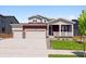 Charming two-story home featuring a covered porch, a three-car garage, and a well-manicured lawn at 1839 Morgan Dr, Erie, CO 80516