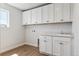 Well-lit laundry room with ample cabinet space, a sink, and modern fixtures at 1839 Morgan Dr, Erie, CO 80516