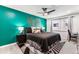 Vibrant bedroom featuring a bold accent wall, contemporary decor, and a ceiling fan at 7375 E Quincy Ave # 202, Denver, CO 80237