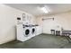 Laundry room with multiple washing machines, sink and folding table at 7375 E Quincy Ave # 202, Denver, CO 80237