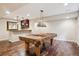 Finished basement features a billiard table, hardwood floors, and a bar with dark wood cabinets at 9362 S Holland Way, Littleton, CO 80127