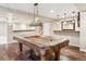 Finished basement features a billiard table, hardwood floors, and a bar with dark wood cabinets at 9362 S Holland Way, Littleton, CO 80127