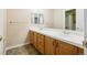 Bathroom with double sinks, light wood cabinets, and tile flooring at 9362 S Holland Way, Littleton, CO 80127
