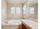 Bright bathroom features double windows over a soaking tub and a nearby vanity at 9362 S Holland Way, Littleton, CO 80127