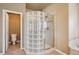 Bathroom featuring an enclosed glass block shower and an adjacent toilet at 9362 S Holland Way, Littleton, CO 80127