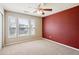 Bedroom featuring a red accent wall and three windows, carpet, and natural light at 9362 S Holland Way, Littleton, CO 80127