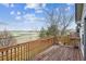 Wooden deck showcases scenic views of farmland and a blue sky with scattered clouds at 9362 S Holland Way, Littleton, CO 80127