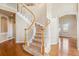Elegant foyer features a curved staircase with white railings and hardwood floors at 9362 S Holland Way, Littleton, CO 80127