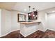 Home wet bar with wood cabinets, sink, marble countertop, and hardwood floors at 9362 S Holland Way, Littleton, CO 80127