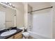 Bathroom featuring a black countertop, white sink, toilet, shower, and tub with white tiling at 4451 S Ammons St # 1-304, Littleton, CO 80123