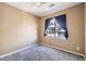 Tan bedroom featuring a ceiling fan, a window with blue curtains, and gray carpeting at 4451 S Ammons St # 1-304, Littleton, CO 80123