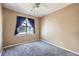 Tan bedroom featuring a ceiling fan, a window with blue curtains, and gray carpeting at 4451 S Ammons St # 1-304, Littleton, CO 80123