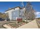 View of condo complex showing signage, blue and gray siding, landscaping and plenty of parking at 4451 S Ammons St # 1-304, Littleton, CO 80123