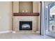 Living room with fireplace featuring light-colored tile, wooden mantel and access to the balcony at 4451 S Ammons St # 1-304, Littleton, CO 80123