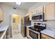 Bright kitchen with stainless steel appliances, white marble countertops, wooden cabinets, and laundry access at 4451 S Ammons St # 1-304, Littleton, CO 80123