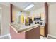 Kitchen with tiled breakfast bar, stainless steel appliances, wooden cabinets, and laundry access at 4451 S Ammons St # 1-304, Littleton, CO 80123