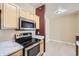 Kitchen with stainless steel oven and microwave, marble counter tops and light hardwood flooring at 4451 S Ammons St # 1-304, Littleton, CO 80123