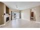 Bright living room with fireplace, white floors, ceiling fan, and a sliding glass door to balcony at 4451 S Ammons St # 1-304, Littleton, CO 80123