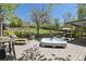 Backyard features a hot tub, an umbrella covered table, and green lawn, perfect for summer fun at 1196 S Quebec Way, Denver, CO 80231