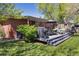 Backyard features a barbecue, grassy lawn, patio and lush tree coverage at 1196 S Quebec Way, Denver, CO 80231