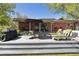 Backyard brick home with patio, outdoor furniture, barbecue and sun bathing chairs at 1196 S Quebec Way, Denver, CO 80231