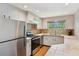 Bright kitchen features stainless steel appliances and tile countertops, perfect for meal preparation and entertaining at 1196 S Quebec Way, Denver, CO 80231