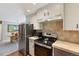 Well-lit kitchen includes stainless steel refrigerator, range, and dining area view, ideal for everyday living at 1196 S Quebec Way, Denver, CO 80231