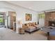 Cozy living room featuring neutral colors, a stone fireplace, and view to kitchen at 1196 S Quebec Way, Denver, CO 80231