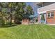 Spacious backyard with a well-maintained lawn, patio area, and mature trees at 3 Winged Foot Way, Littleton, CO 80123