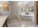 Bathroom featuring a glass enclosed shower, soaking tub, and view at 3 Winged Foot Way, Littleton, CO 80123