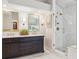 Modern bathroom with double vanity, marble countertop, and glass enclosed shower at 3 Winged Foot Way, Littleton, CO 80123