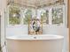 Bright bathroom featuring a soaking tub and a beautiful window view of the outdoors at 3 Winged Foot Way, Littleton, CO 80123