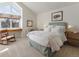 Bright bedroom with a large window, rocking chair, comfortable bed with white linens, and neutral carpet at 3 Winged Foot Way, Littleton, CO 80123