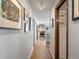 Hallway with hardwood floors leads to a kitchen with stainless steel appliances and white cabinetry at 3 Winged Foot Way, Littleton, CO 80123