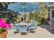 Outdoor dining area with table, chairs, umbrella, and beautifully landscaped surroundings at 3 Winged Foot Way, Littleton, CO 80123