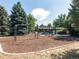 Community playground featuring swings, a slide, and play structures, surrounded by lush trees at 3 Winged Foot Way, Littleton, CO 80123