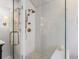 Detailed view of glass shower with white subway tiles and gold shower hardware at 3 Winged Foot Way, Littleton, CO 80123