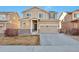 Two-story house with a beige exterior, two-car garage, and a landscaped yard at 9553 Cherry Ln, Thornton, CO 80229