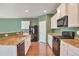 Modern kitchen with stainless steel appliances and green accent wall at 9553 Cherry Ln, Thornton, CO 80229