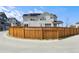 Home exterior featuring a backyard with wood fence, solar panels, and manicured landscaping at 2862 E 103Rd Ave, Denver, CO 80229