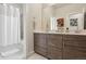 Modern bathroom featuring a double vanity, a mirror, and a shower with glass door at 2862 E 103Rd Ave, Denver, CO 80229