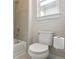 Clean bathroom featuring a toilet, bathtub with shower, and bright natural light at 2862 E 103Rd Ave, Denver, CO 80229