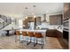 Stylish kitchen with an island and seating with modern appliances and fixtures, and an open dining area at 2862 E 103Rd Ave, Denver, CO 80229