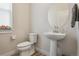 Cozy powder room with pedestal sink, round mirror, and decorative touches at 2862 E 103Rd Ave, Denver, CO 80229