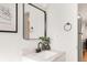 Bathroom vanity with a black faucet, decorative mirror, and greenery at 155 S Pennsylvania St # 205, Denver, CO 80209