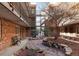 Courtyard view of a brick apartment building, with landscaping and seating at 155 S Pennsylvania St # 205, Denver, CO 80209